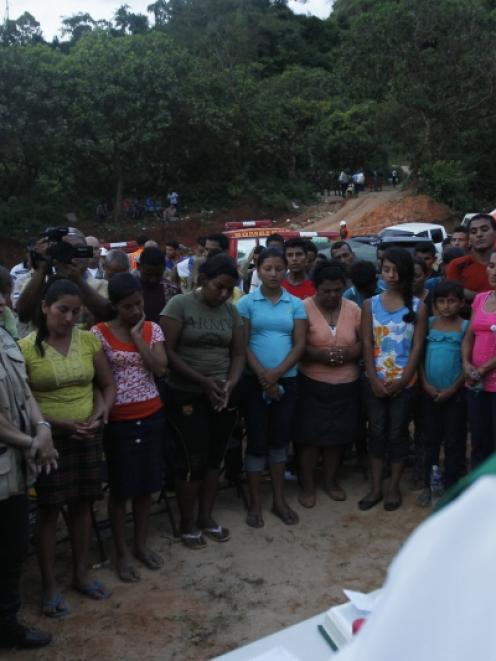 Relatives and friends of eight miners trapped in a gold mine affected by a landslide pray during...