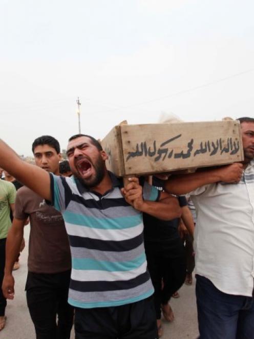 Relatives carry the coffin of an Iraqi police officer killed by militants, during a funeral in...