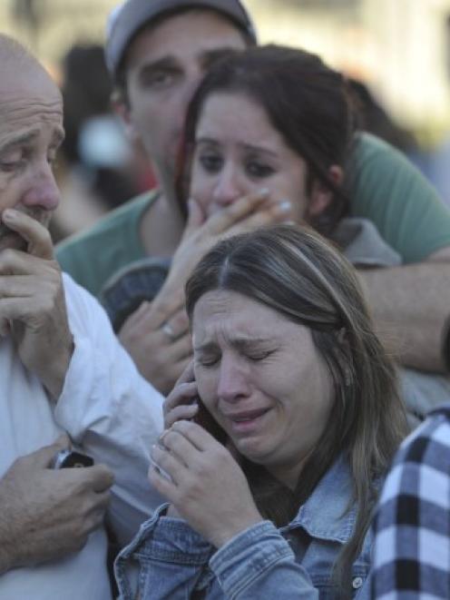 Relatives of victims cry in the southern city of Santa Maria, Brazil, where a nightclub fire...