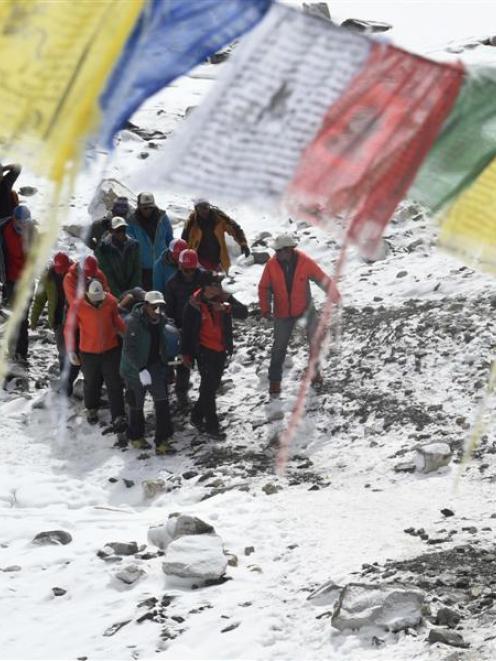 Rescue team personnel carry an injured person at Everest Base Camp on April 26, 2015. Photo by...