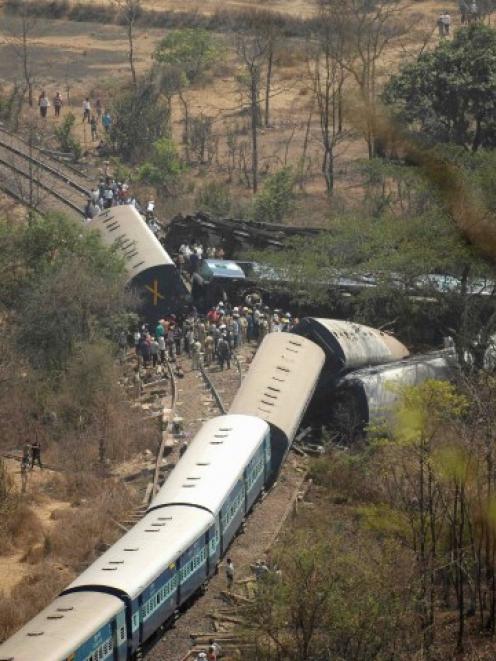 Rescuers and police stand next to damaged coaches of the derailed train. REUTERS/Stringer