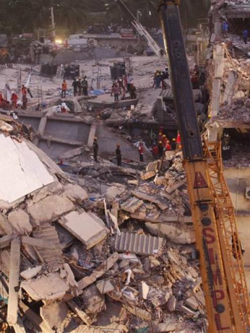 Rescuers attempt to save garment workers from the rubble of the collapsed Rana Plaza building, in...