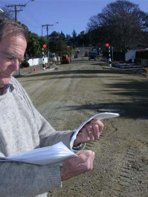 Reservoir Rd resident Denis Dove studies a 279-signature petition opposing the closure of Ouse St...