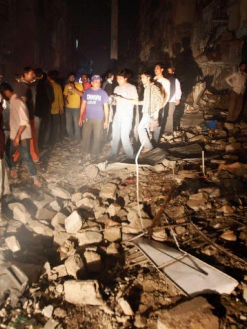 Residents and rescue workers gather at the site of a bomb blast in a residential area in Karachi....