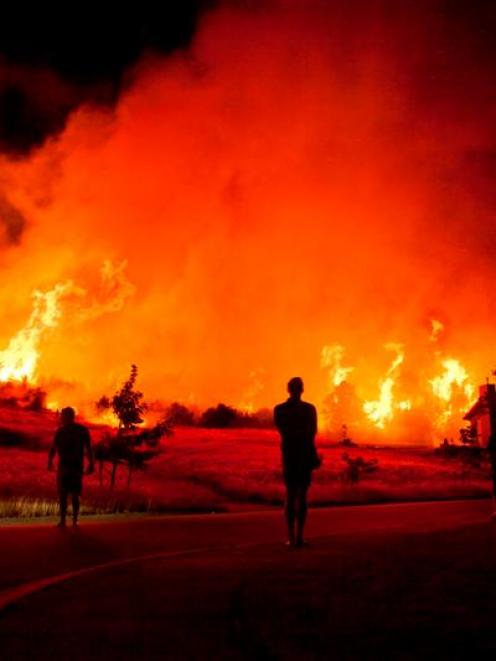 Residents are silhouetted against the blaze bordering the Mt Iron subdivision in Wanaka at 4.30am...