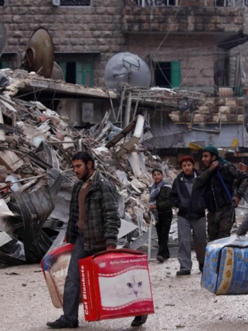 Residents evacuate their houses after being targeted by missiles fired by forces loyal to Syria's...