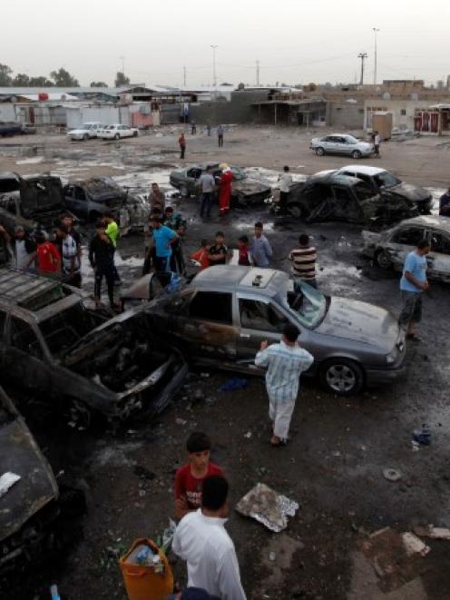Residents gather at the site of a car bomb attack in Baghdad's Sadr City. REUTERS/Thaier al-Sudani
