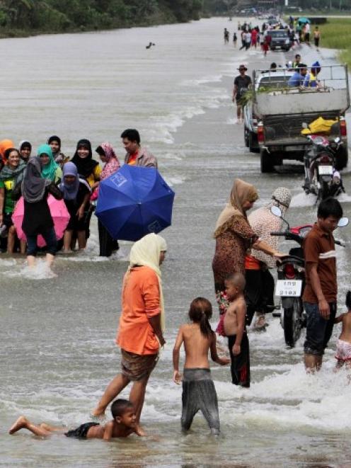 Residents make their way on a flooded road in Pattani province in Thailand. REUTERS/Surapan...