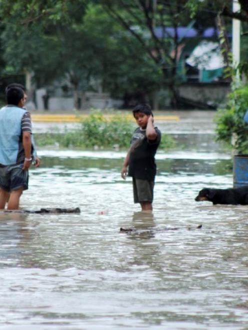 Residents wade through a flooded street in Poza Rica, in the Mexican state of Veracruz. REUTERS...