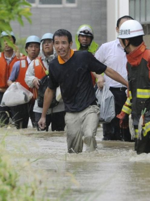 Residents walk in a flooded street to evacuate in Nagoya, central Japan, yesterday. Photo:...