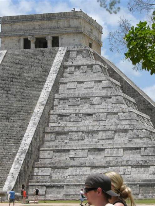 Restored to its former grandeur on two sides, the central pyramid dominates the archaeological...