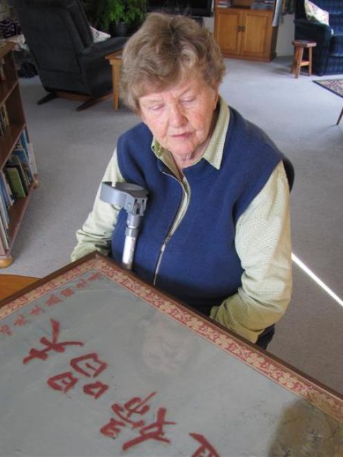 Retired Presbyterian Minister Catherine Little, of Wanaka, studies the embroidered silk plaque...