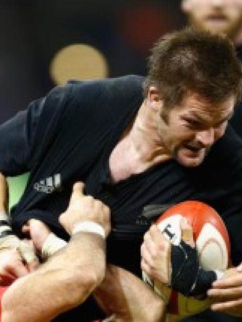 Richie McCaw of the All Blacks is tackled during the Intenational match between Wales and the New...