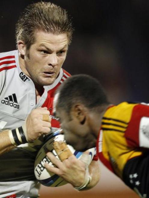 Richie McCaw, of the Crusaders, runs the ball at Sitiveni Sivivatu, of the Chiefs, in a Super...