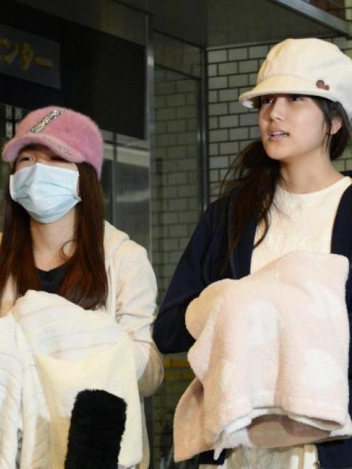 Rina Kawaei (L) and Anna Iriyama speak to the media as they are discharged from a hospital in...