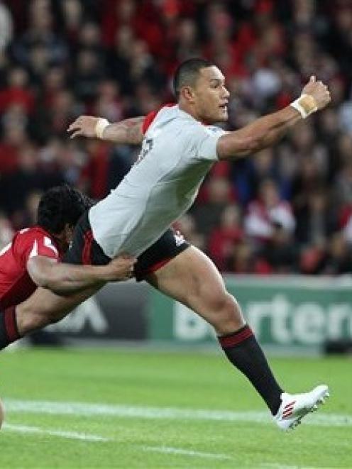 Robbie Fruean of the Crusaders, right, is tackled by Ben Tapuai of the Reds. (AP Photo/Tertius...
