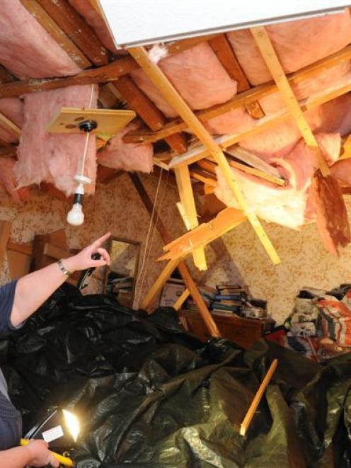 Rochelle Wilson shows where a huge wattle tree hit her house yesterday, demolishing much of the...
