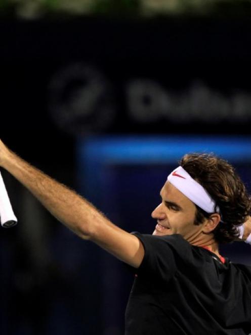 Roger Federer of Switzerland celebrates after beating Andy Murray of Britain to win the Dubai...