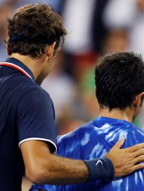 Roger Federer of Switzerland (L) pats Bjorn Phau of Germany on the back after defeating him at...