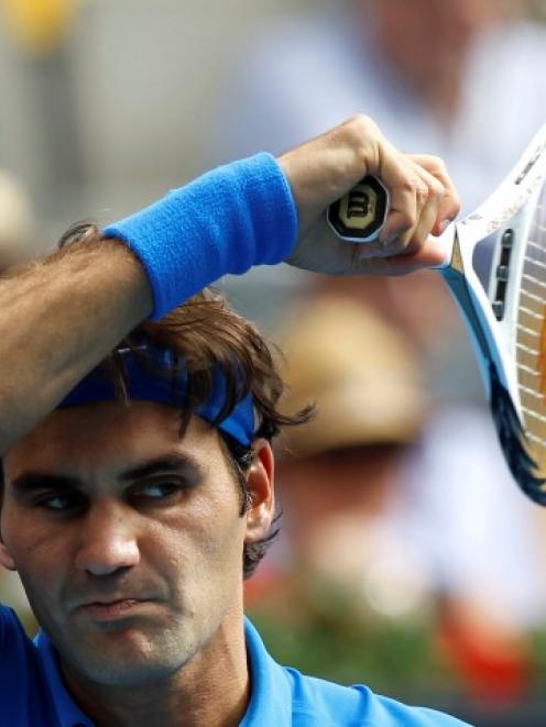 Roger Federer of Switzerland returns the ball to Tomas Berdych of the Czech Republic during their...