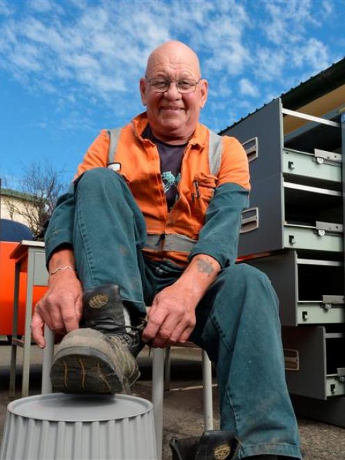 Roger Parsons removes his work boots for the last time yesterday,  signalling his retirement...