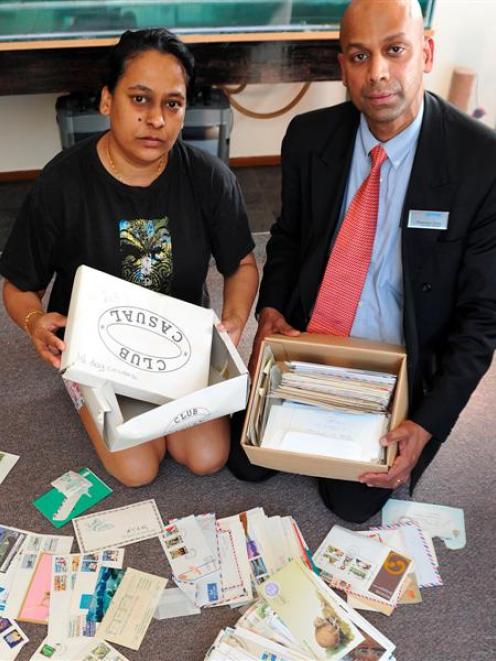 Romeni (left) and Dharama Sena look over the postcard covers, letters, envelopes and stamps they...