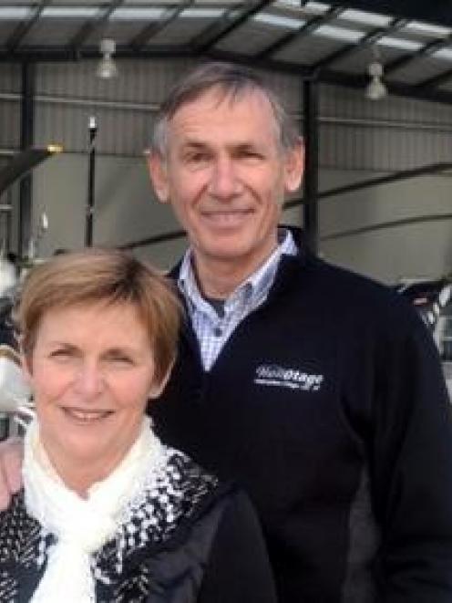 Ros and Graeme Gale in front of a hangar bay with their fleet of Jet Ranger helicopters. Photo by...