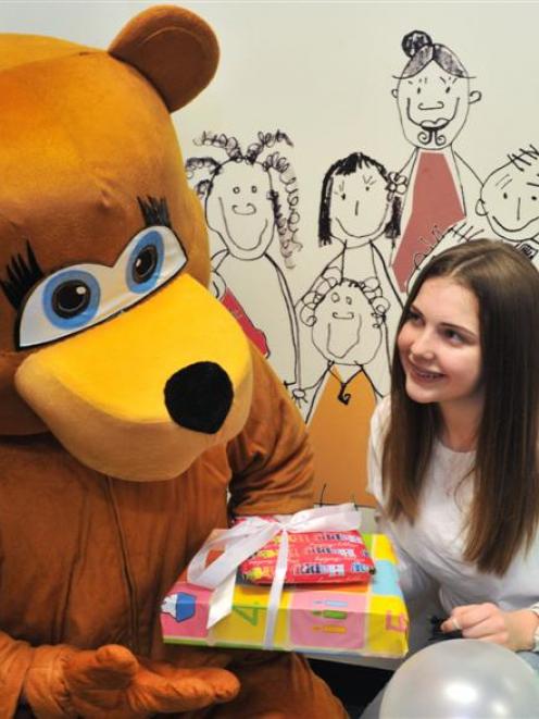 Rosaria Marsh (15), of Dunedin, gives presents to Foster Bear, the Child, Youth and Family mascot...