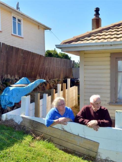 Rose McRobie and her father  examine the retaining wall  they had to build  in their backyard...