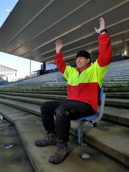 Rotarian Brendan Bearman tries out one of the last seats left in the Railway Stand at Carisbrook...