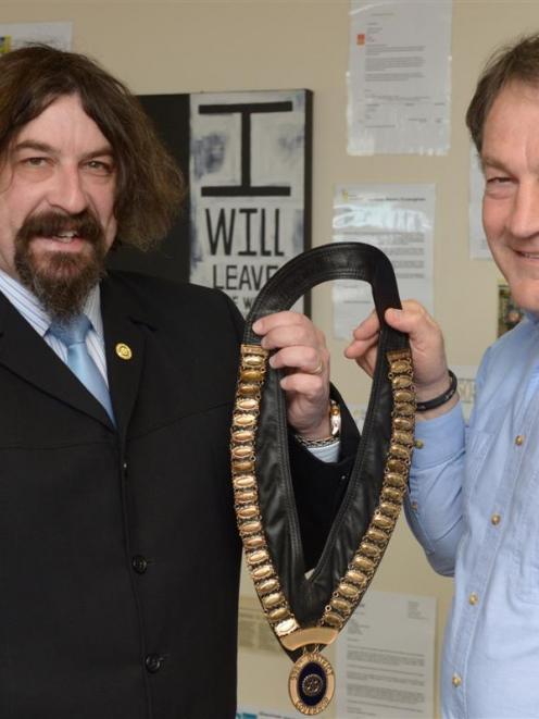 Rotary's new district governor Jonathan Usher (left) accepts the chain of office from Gary...