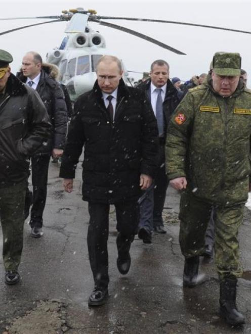 Russia's President Vladimir Putin (centre), accompanied  by Russian Defence Minister Sergei...