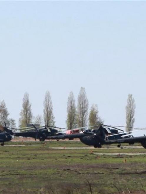 Russian military helicopters are seen in a field outside the village of Severny in the Belgorod...