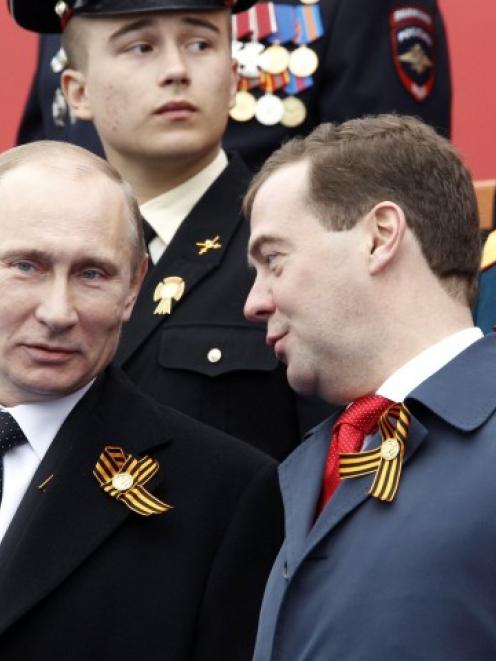 Russian President Vladimir Putin (L) and Prime Minister Dmitry Medvedev watch the Victory Parade...