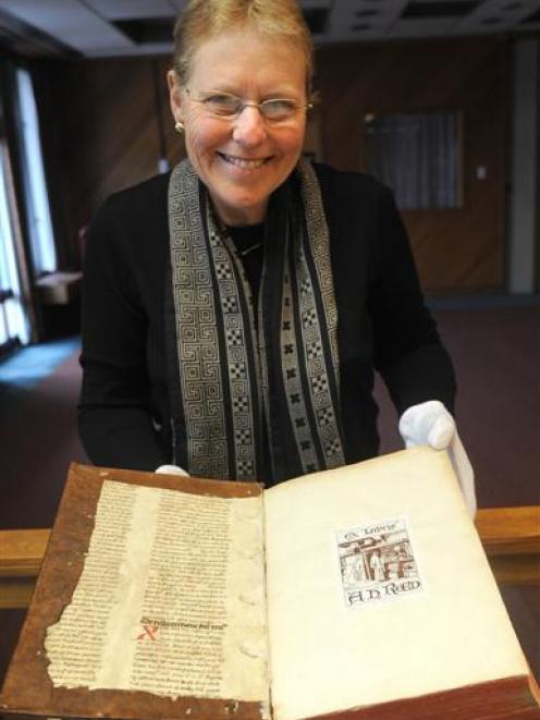 Ruth Lightbourne, curator of the Alexander Turnbull rare book collection, examines a 15th century...