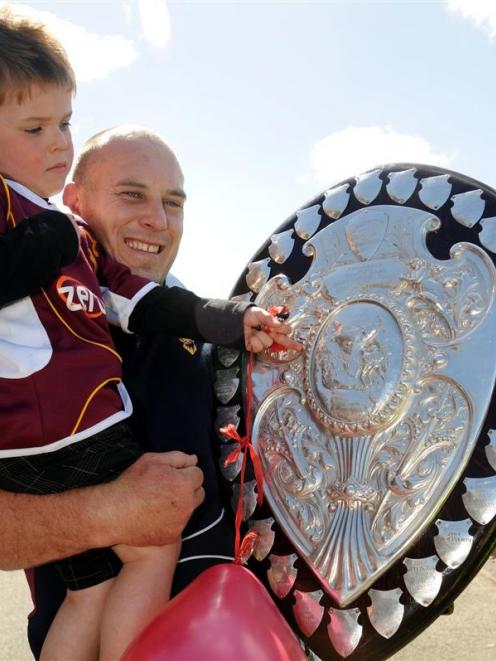 Rutledge holds two precious possessions, son Gregor (3) and the Ranfurly Shield, after Southland...