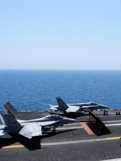 Sailors launch aircraft from the flight deck of the aircraft carrier USS George H.W. Bush (CVN 77...