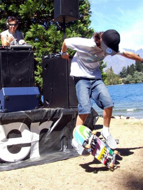 Sam Maxwell, of Queenstown, performs tricks on his skateboard, while DJ Matt Smith entertains the...