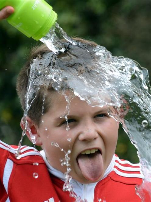 Sam McCormack, of Dunedin, pours a bottle of cold water over himself at Wingatui Racecourse in...