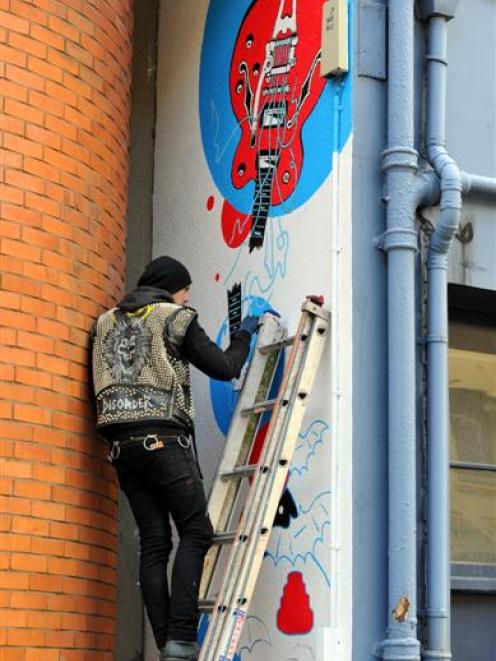 Sam Ovens, of Dunedin, wearing his distinctive studded vest as he works on a piece for the Vogel...