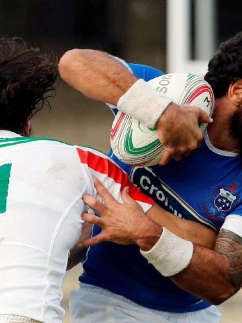 Samoa's Kahn Fotualii (R) is caught by Italy's Leonardo Sarto. REUTERS/Giampiero Sposito