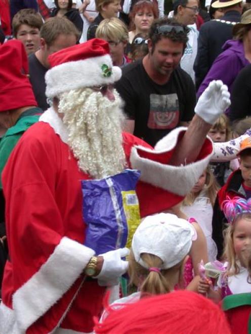 Santa Claus attracts a big crowd for a lolly scramble after he arrives at the Waimate Strawberry...