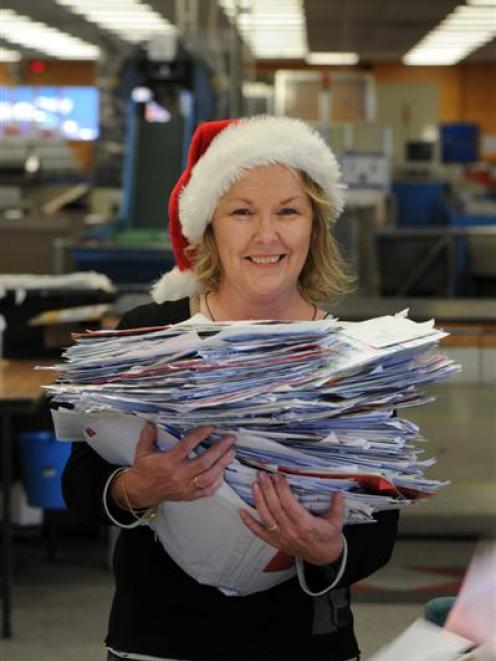 Santa's letter helper Colleen Eckhoff, of New Zealand Post, sorts through piles of Dear Santa...