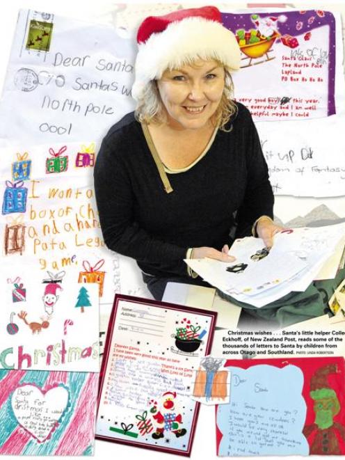Santa's little helper Colleen Eckhoff, of New Zealand Post, reads someof the thousands of letters...