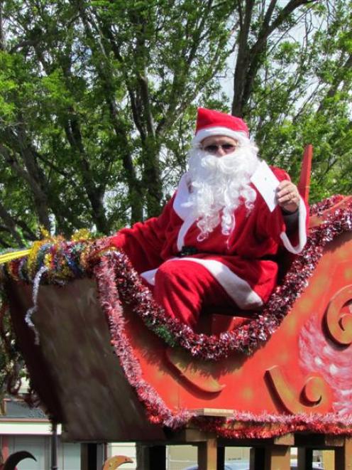 Santa waves to the crowd at the Oamaru Christmas Parade. Photo by Andrew Ashton.