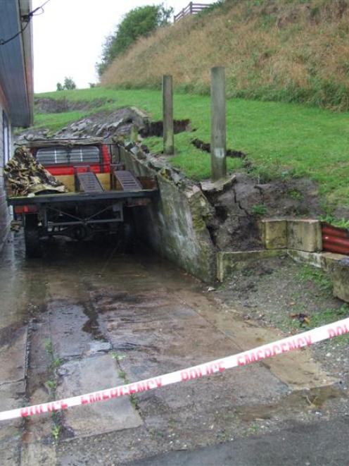 Saturated land behind this Aln St house collapsed a retaining wall on to a ute on Friday night,...