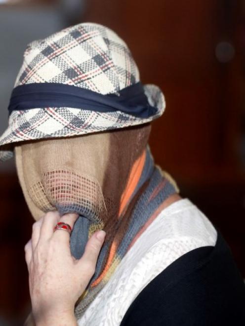 Schapelle Corby has her head covered as she sits in the Denpasar Parole board office following...