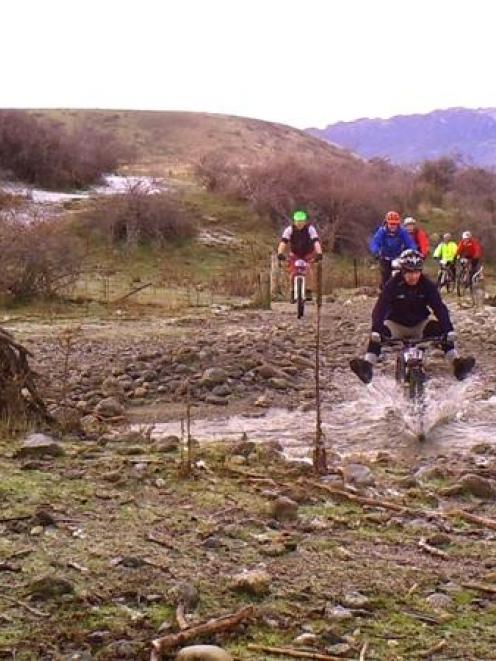 Scot Pollard, of Alexandra, makes sure to keep his feet out of the water on a creek crossing...