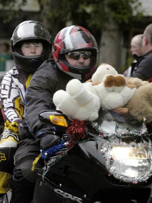 Sean (12) and Lyall Johnston, of Dunedin, ride through central Dunedin during the BRONZ Otago...