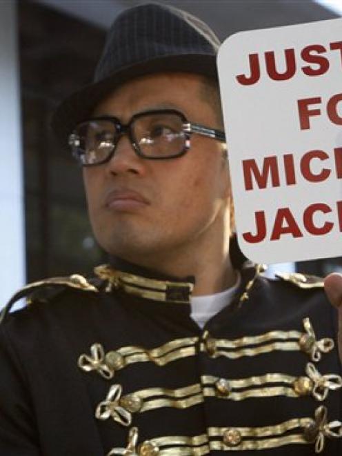 Sean Kang, a Michael Jackson fan from New York, holds up a sign in protest to Michael Jackson's...